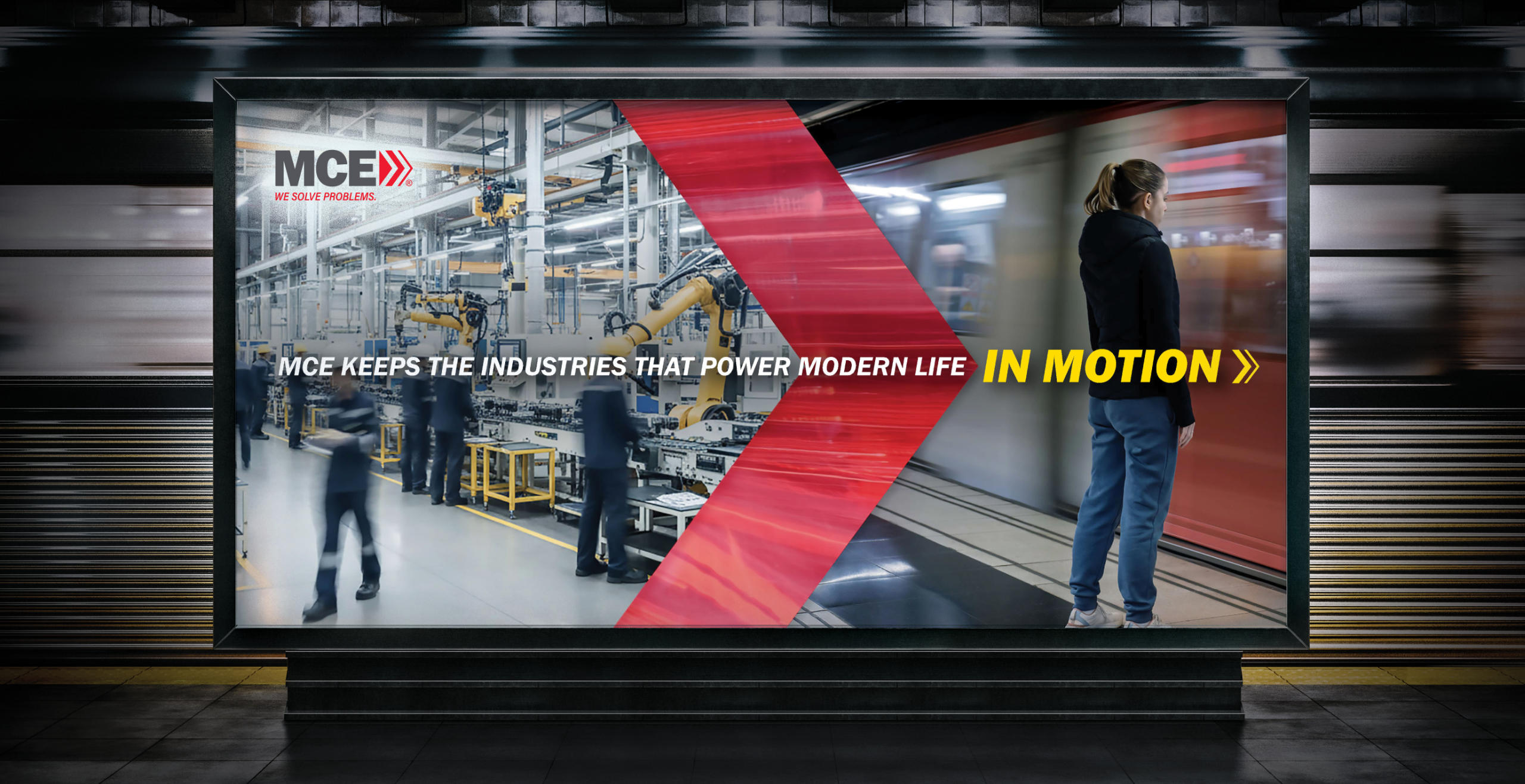 a video monitor in a train station shows an image of an advanced factory transforming into a train arriving at a station